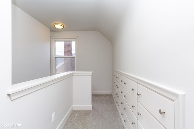 spacious closet featuring lofted ceiling and light colored carpet