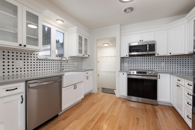 kitchen featuring white cabinetry, sink, light hardwood / wood-style flooring, and stainless steel appliances