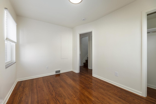 unfurnished bedroom with a closet and dark hardwood / wood-style floors