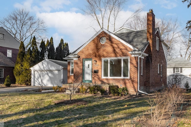 view of front of property with a garage, an outbuilding, and a front lawn