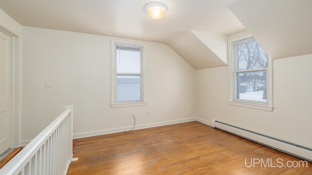 bonus room with vaulted ceiling, light wood-type flooring, and baseboard heating