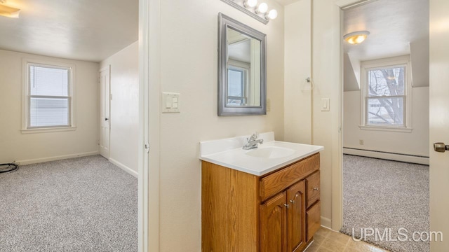 bathroom featuring baseboard heating and vanity