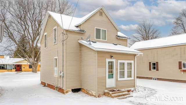 view of snow covered rear of property