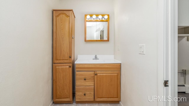 bathroom featuring baseboard heating and vanity