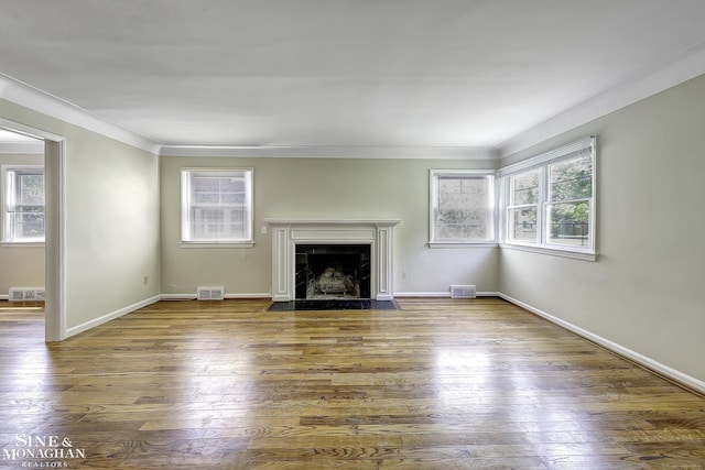 unfurnished living room with wood-type flooring and ornamental molding