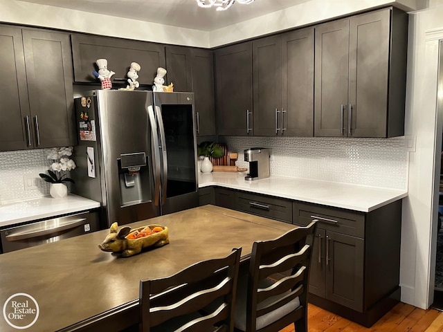 kitchen with tasteful backsplash, dark brown cabinetry, appliances with stainless steel finishes, and light wood-type flooring