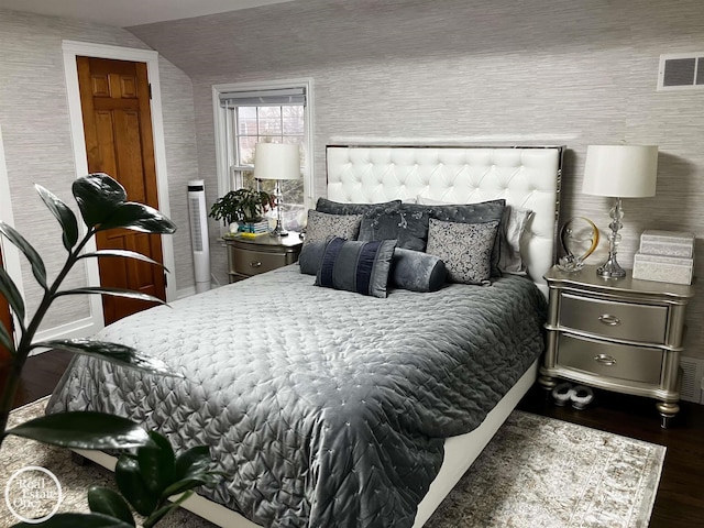 bedroom with vaulted ceiling and dark hardwood / wood-style flooring