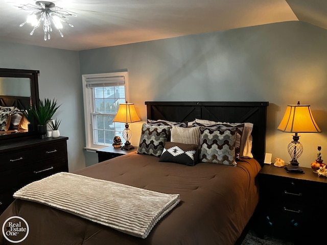 bedroom with lofted ceiling and an inviting chandelier