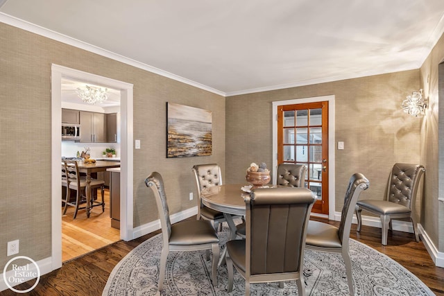 dining room featuring dark hardwood / wood-style flooring, crown molding, and a chandelier