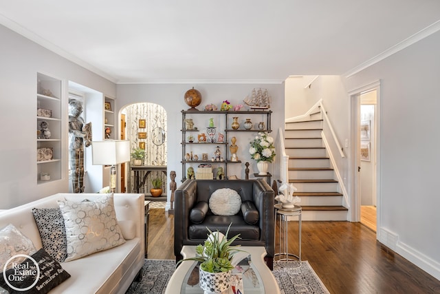 living room featuring dark hardwood / wood-style flooring, built in shelves, and ornamental molding