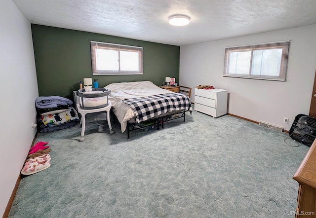 bedroom with carpet floors and a textured ceiling