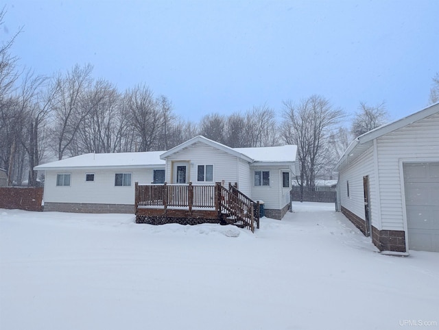 snow covered back of property featuring a wooden deck