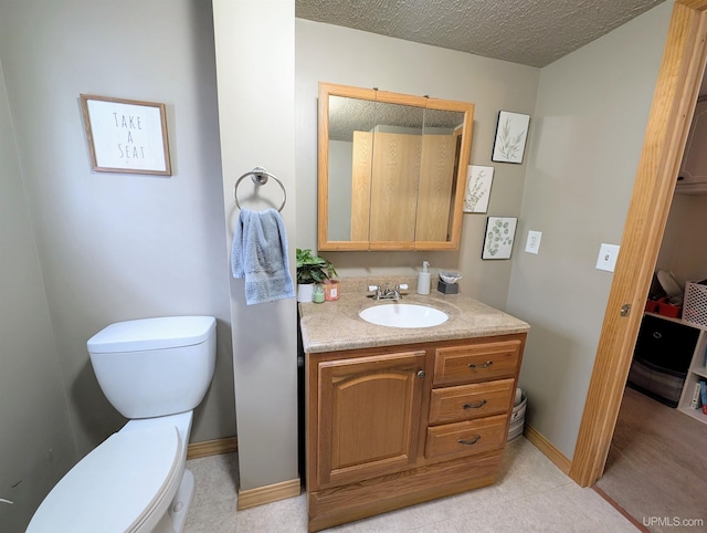 bathroom featuring vanity, toilet, and a textured ceiling