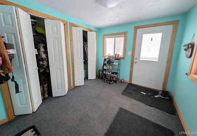 interior space featuring dark carpet and a textured ceiling