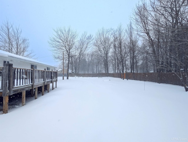 yard covered in snow with a wooden deck