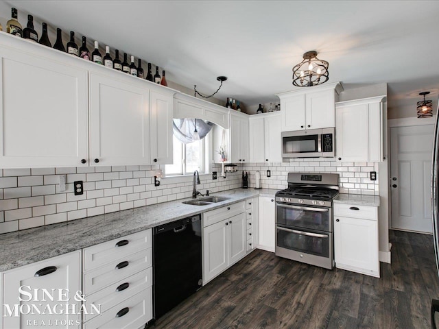 kitchen with light stone countertops, white cabinetry, appliances with stainless steel finishes, and sink