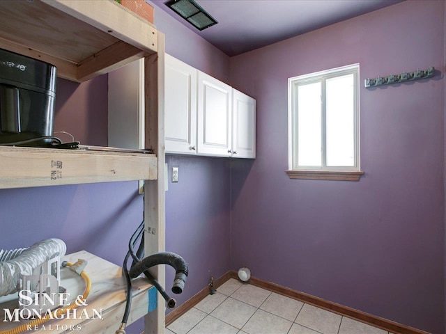 clothes washing area featuring light tile patterned flooring, cabinets, and gas dryer hookup