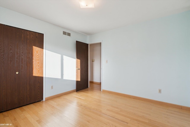 unfurnished bedroom featuring light hardwood / wood-style floors and a closet