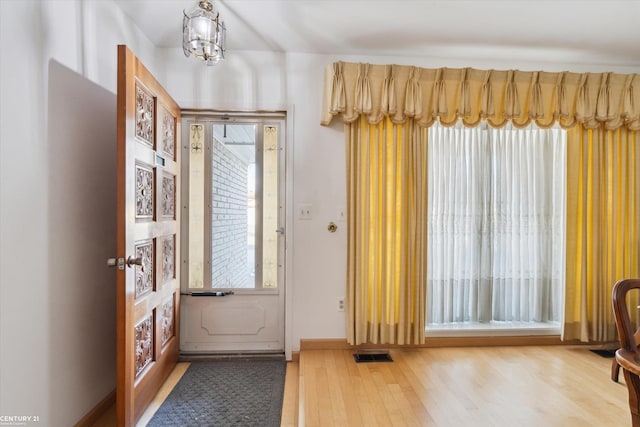 foyer with wood-type flooring and a chandelier