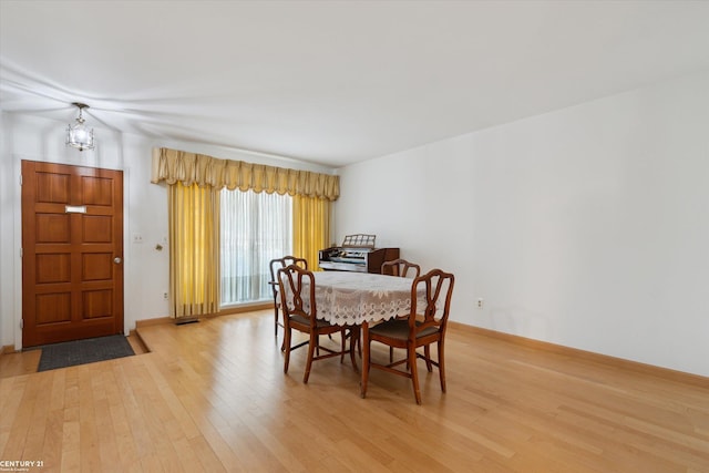 dining space with an inviting chandelier and light hardwood / wood-style flooring