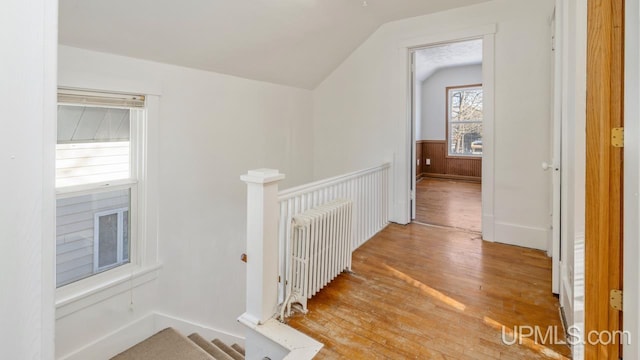 hall featuring lofted ceiling, radiator, and light hardwood / wood-style floors