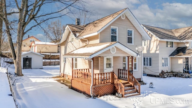 view of front of house with a storage shed and a porch