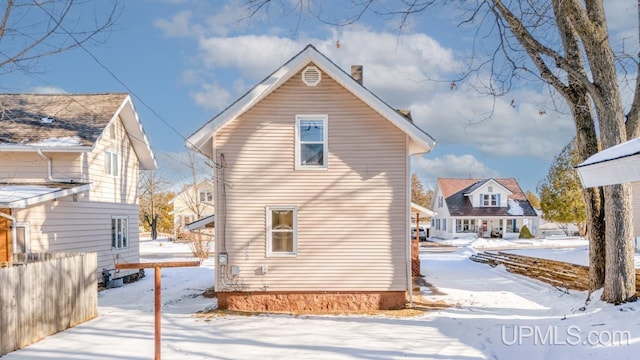 view of snow covered back of property