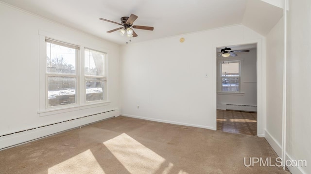 carpeted spare room featuring a baseboard heating unit, crown molding, and ceiling fan