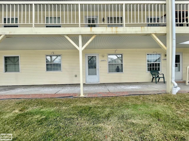 back of house with a patio area and a lawn