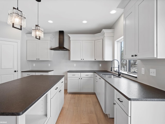 kitchen featuring a kitchen island, decorative light fixtures, sink, white cabinets, and wall chimney exhaust hood