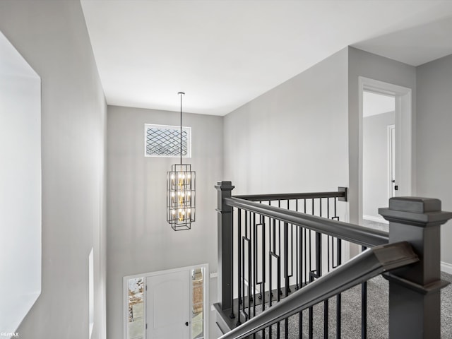 hall with carpet and a notable chandelier