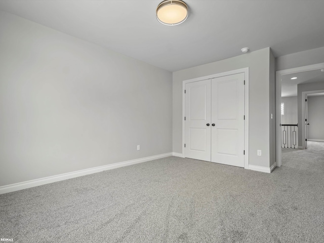 unfurnished bedroom with light carpet and a closet