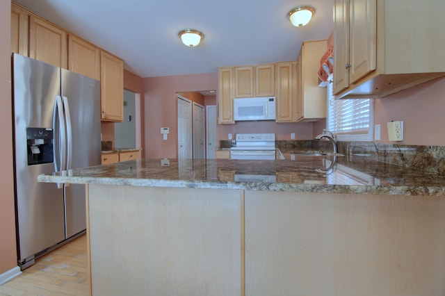 kitchen featuring sink, white appliances, stone counters, light brown cabinetry, and kitchen peninsula