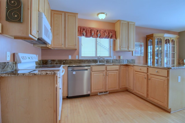 kitchen with light brown cabinetry, sink, stainless steel dishwasher, kitchen peninsula, and light wood-type flooring