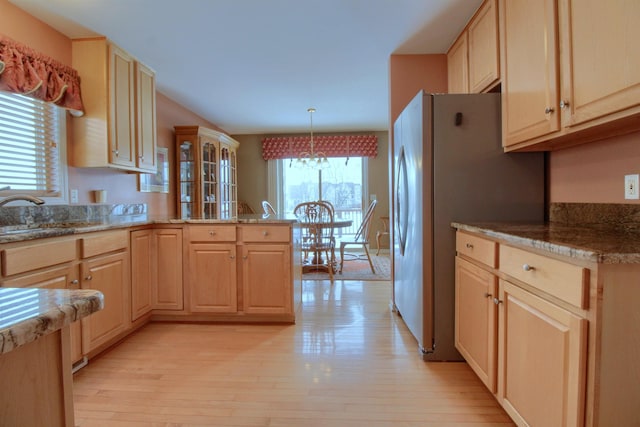 kitchen featuring sink, pendant lighting, light brown cabinets, and light hardwood / wood-style flooring