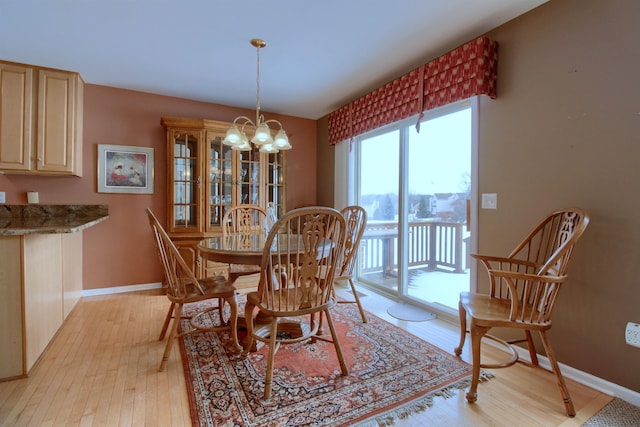 dining room with light hardwood / wood-style flooring and a chandelier