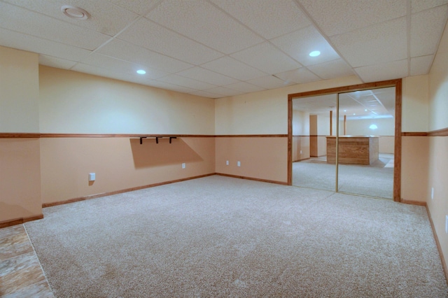 carpeted empty room with a paneled ceiling