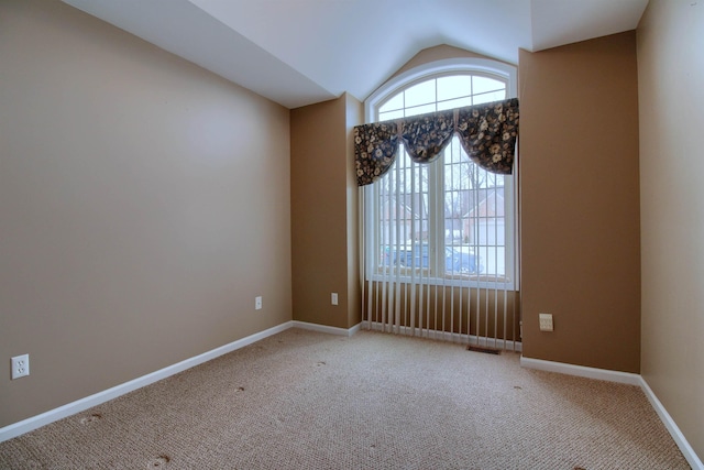 carpeted empty room with lofted ceiling