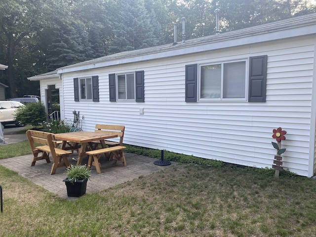 back of house with a patio and a lawn