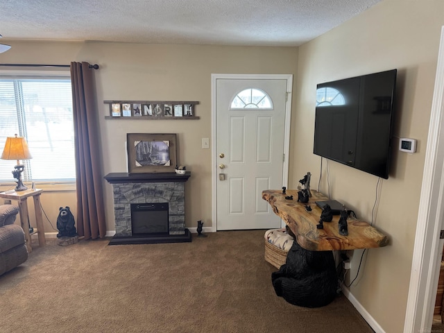 carpeted foyer entrance featuring a fireplace and a textured ceiling