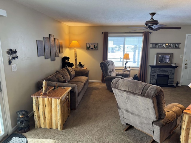 living room with a stone fireplace, a textured ceiling, ceiling fan, and dark colored carpet