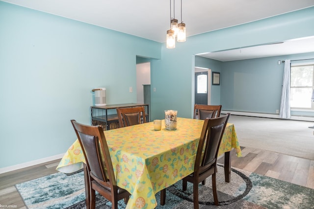 dining space featuring wood-type flooring and a baseboard heating unit