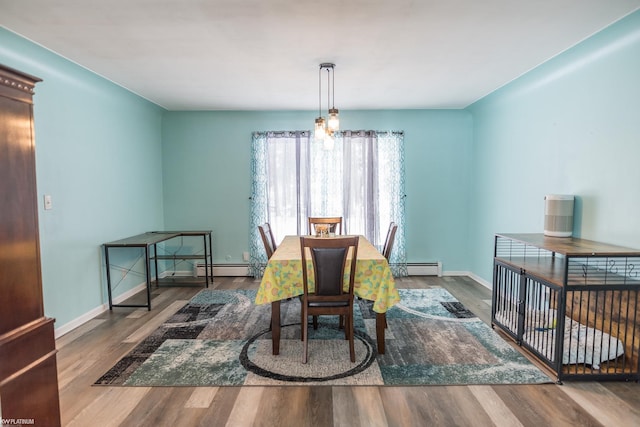 dining space with hardwood / wood-style flooring and a baseboard radiator