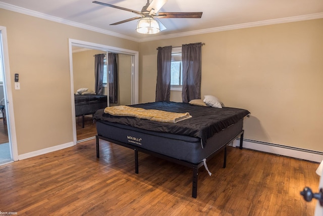 bedroom with hardwood / wood-style flooring, ceiling fan, baseboard heating, crown molding, and a closet