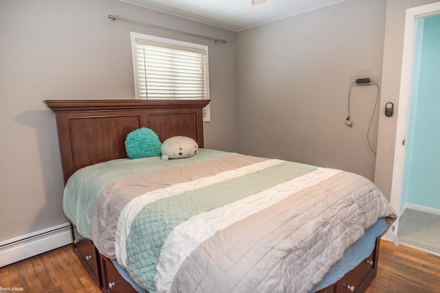 bedroom featuring a baseboard heating unit and dark hardwood / wood-style floors