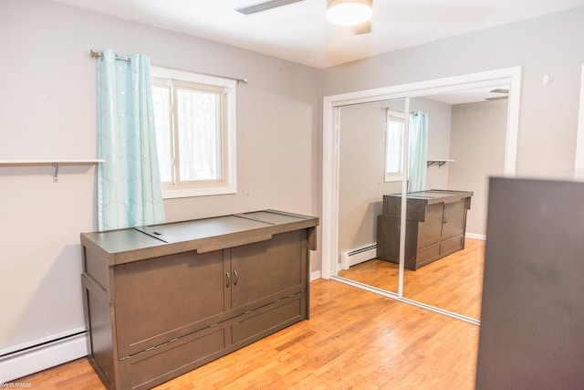 interior space featuring baseboard heating, plenty of natural light, and light wood-type flooring