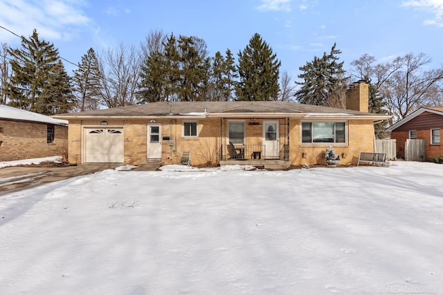 snow covered property with a garage