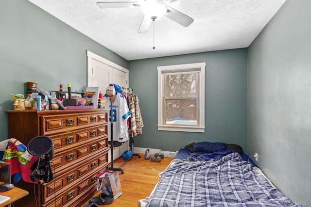 bedroom with hardwood / wood-style floors, a textured ceiling, and ceiling fan