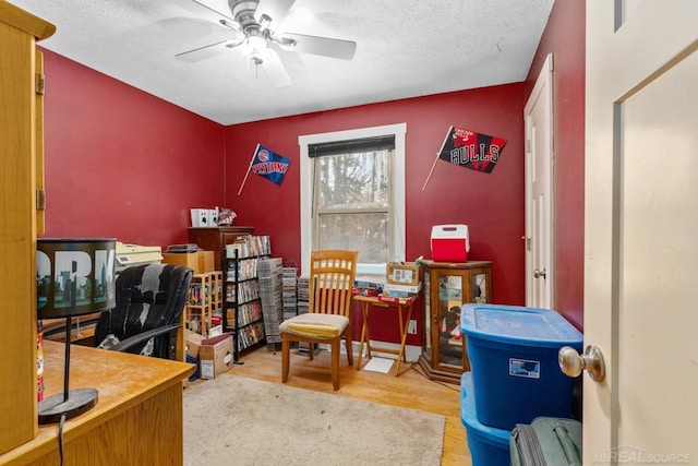 office featuring ceiling fan, light hardwood / wood-style flooring, and a textured ceiling