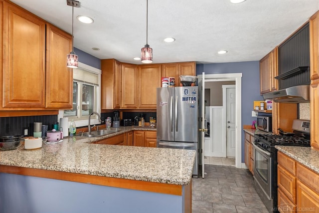 kitchen featuring pendant lighting, stainless steel appliances, light stone countertops, and sink